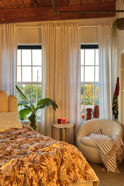 A warm and inviting reading nook in a bedroom with wooden beams and sheer curtains. The space includes a leopard print blanket on the bed, a plush round chair with a striped throw, candles on a side table, and a hanging plant, creating a serene retreat. Reading Corner Home, Space Reading Corner, Bedroom Decor Amazon, Moving Into First Home, Reading Nook Bedroom, Nook Bedroom, Bedroom Reading Nook, Maximalist Interior Design, Maximalist Interior