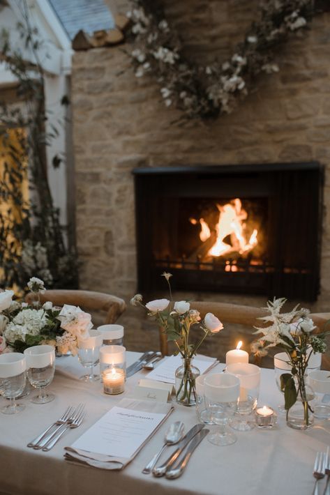 A fireplace glows beside a wedding table that is decorated in a festive manner Cosy Winter Wedding, Winter Wedding Uk, Cosy Wedding, Daylesford Farm, Bud Vase Centerpiece, Wedding Feast, Winter Wedding Venues, Green Weddings, Vase Centerpiece