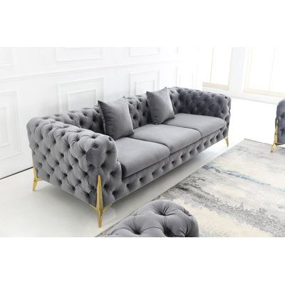 Both inviting and elegant, this sofa encourages lingering and long conversations. An eye-catching piece that adds a luxe look and feel to your living room. Plush velvet upholstery offers an elegant look, button-tufting adding a trendy touch. Gold metal legs peak out underneath for a sleek design. Fabric: Gray Velvet | Everly Quinn Johnitta Velvet in Gray, Size 27.5 H x 96.0 W x 37.0 D in | Wayfair Formal Living Room Designs, Sofa Blue, Sofa Gray, Sofa Velvet, Modern Sofa Living Room, Velvet Living Room, Fabric Gray, Toss Pillow, Sofa Set Designs