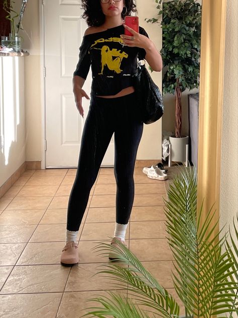 A chill black outfit consents of a black shirt with a yellow detour graphic design paired with black leggings, white socks and pink Birkenstocks. Leggings Outfit With Birkenstocks, Pink Birkenstocks Outfits, Birkenstocks Outfits, Pink Birkenstocks, Birkenstock Clogs Outfit, Birkenstock Outfit, Clogs Outfit, Chill Fits, Flared Leggings