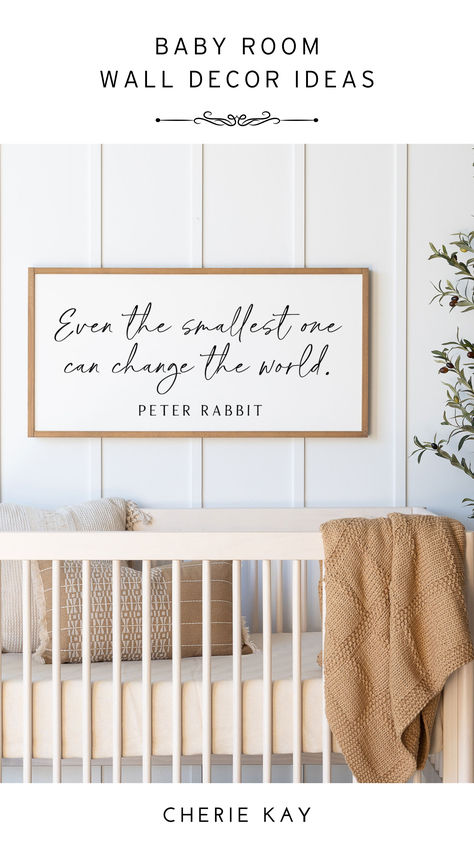 A cozy nursery with a wooden crib adorned with neutral-toned bedding and a knitted blanket draped over the edge. Above the crib hangs a framed sign with the quote "Even the smallest one can change the world." by Peter Rabbit. The room has a serene and minimalist design, perfect for a baby’s room. Nursery Signs Quotes, Toddle Room, Nursery Wall Quotes, Batten Board, Panda Nursery, Peter Rabbit Nursery, Baby Room Wall Decor, Nursery Quotes, Adorable Nursery