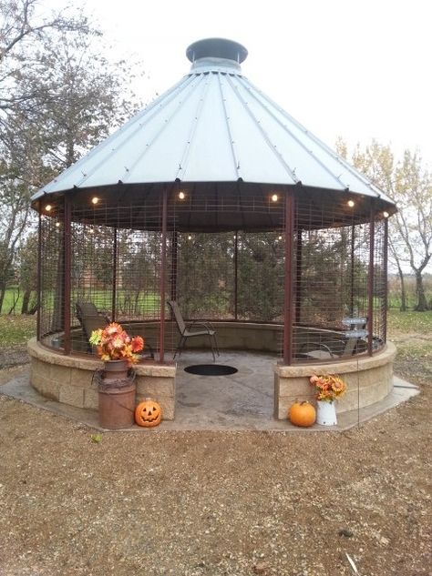 We saved this corn crib for 20+ years for a gazebo, and it finally came to be built last fall. We will add screens and screen door, & landscaping this summer ! Due to the mild winter so far, we have enjoyed many bonfires in it already. We love it ! Worth the time and $$. Corn Silo Ideas, Corn Silo Gazebo, Corn Bin Ideas, Corncrib Gazebo Ideas, Corn Bin Gazebo, Corn Crib Fire Pit, Cabin Yard Ideas, Corn Crib Gazebo Ideas, Corn Crib Ideas