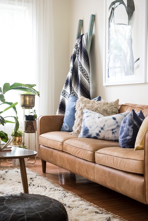 Boho living room decor: brass planters, caramel leather sofa, indigo textiles, Moroccan leather pouf, warm wood accents pieces Boho Lodge, Caramel Leather Sofa, Glass Coffee Table Decor, Swallow Nest, Brass Planters, Apartment Living Room Decor, Best Leather Sofa, Indigo Textiles, Boho Living Room Decor