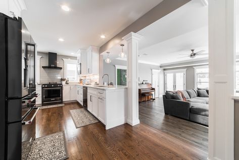 Open concept kitchen with a load bearing wall removal. The pillars allow for structural support while still acheiving an open area. #OpenConcept #OpenKitchen #KitchenAidRange #BlackStainlessSteel #BlackStainlessSteelAppliances #KitchenAidRefridgerator #BlackKitchenAidRange #SubwaytileBacksplash #WhiteKitchen #WhiteKitchenCabinetry #KitchenAidHood #KitchenAidKitchen #GreyKitchen #CoolToneKitchen #WoodFlooring #TrendyKitchen #KitchenRemodel #KitchenDesign #Pillars #MatteBlackAppliances Kitchen With Columns Load Bearing Wall, Closed Concept Kitchen, Half Open Kitchen, Kitchen Partition Design, Wall Between Kitchen And Living Room, Open Kitchen Partition Ideas, Kitchen Partition Ideas, Kitchen Columns, Open Concept Kitchen Living Room Layout