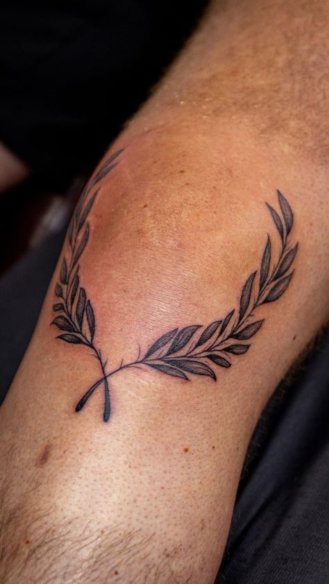 #greektattoo #olivebranchtattoo #olivetattoo #olivebranch #kneetattoo Olive Branch Band Tattoo, Olive Branch Tattoo Leg Wrap, Knee Laurel Tattoo, Roman Crown Tattoo, Olive Branch Wreath Tattoo, Italian Culture Tattoos, Olive Leaf Tattoo Arm, Mens Olive Branch Tattoo, Cross With Olive Branch Tattoo