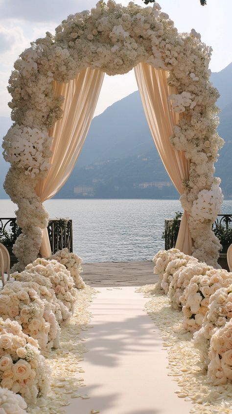 Dreaming of a stunning outdoor wedding at Lake Como? 🌺✨ Picture elegant floral decor with white roses and peonies, framed by majestic mountains. Your special day deserves the perfect capture! 📷 Visit my website for exceptional wedding videography. #Midjourney #LakeComoWedding #WeddingVideographer #FloralDecor Lake Como Wedding Decor, Floral Decor Ideas, Wedding At Lake, Barcelona Wedding, Roses And Peonies, Wedding Spain, Dream Wedding Decorations, Como Wedding, Wedding Party Planning