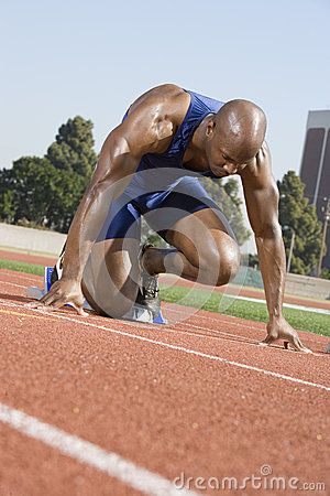 Full length of an African American male runner in the start up position at racetrack. Description from dreamstime.com. I searched for this on bing.com/images Running Reference, Male Runner, Male Photography, Stock Photography Free, Race Track, Fitness Lifestyle, The Start, Pose Reference, African American