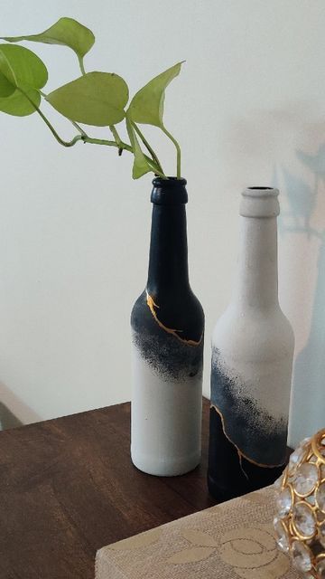 Uttara shared a post on Instagram: ""Kintsugi" is the Japanese art of repairing broken pottery by mending with a mix of lacquer and powdered gold. Inspired by this beautiful art, I present to you these upcycled bottles that will add some class to any corner. I covered the bottles first with chalk paint and then used black and gold @fevicryl_art acrylic paints for the effect. #paintedbottles #bottleart #monochrome #kintsugi #kintsugiart #japaneseinspiration #repurposeddecor #blackwhitegold #bo Black Bottle Painting Ideas, Glass Bottle Acrylic Painting, Painting Glass Bottles Acrylic, Glass Bottle Painting Acrylics, Acrylic Painting On Glass Bottles, Glass Bottle Painting Ideas Acrylic, Bottle Painting Ideas Acrylics, Beer Bottle Painting, Glass Bottle Painting