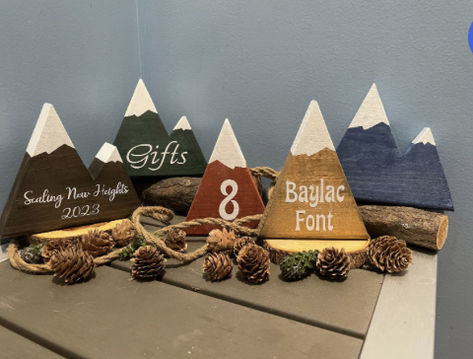 Decorative wooden mountains are perfect for wedding centerpieces, bridal shower decorations, nurseries or rustic decor.   Mountain peaks can be easily customized by adding lettering or numbering.  Mountains can be purchased as single, twin, triple or quad  peaked and can feature white snow caps if desired.  Standard mountain dimensions are approximately 6" x 6" . High quality permanent vinyl personalization (custom) available! We do special requests! Wood Mountain Centerpiece, Wedding Table Numbers Mountains, Mountain Themed Wedding Decor, Mountain Centerpieces, Table Number Photos, Mountain Table Numbers, Wooden Mountains, Family Reunion Keepsakes, Party Van