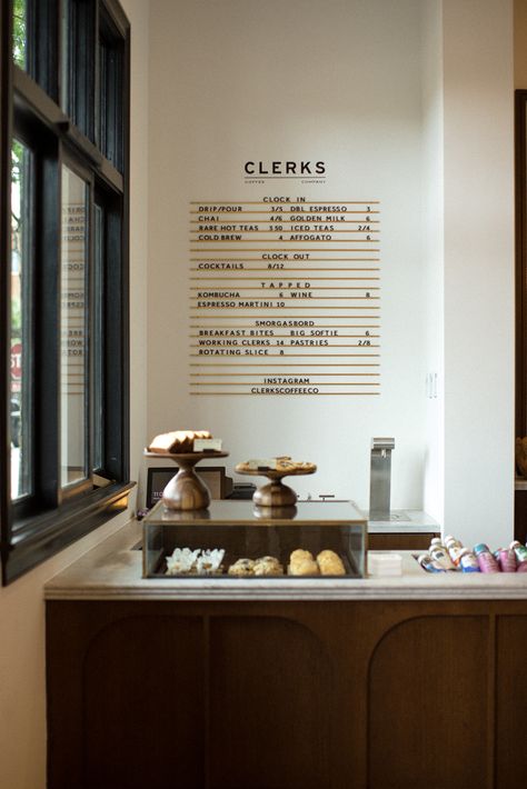 An inviting coffee shop experience with a buzzing atmosphere that behaves as a natural extension of Emeline. Airy and buzzing, Clerks Coffee Company is timeless with a hint of nostalgia and an underlying warmth. The space honors the local craftsmanship of old and new with an assemblage custom millwork, furnishings, lighting and décor. #Branding #Naming #CoffeeShop #InteriorDesign #Signage #MillworkDesign #Logo #Menu Black Counter Coffee Shop, Coffee Shop Counter Design, Scandinavian Coffee Shop, Boutique Coffee Shop, Minimalist Coffee Shop, Coffee Shop Tables, Coffee Shop Names, Coffee Shop Counter, Coffee Shop Lighting