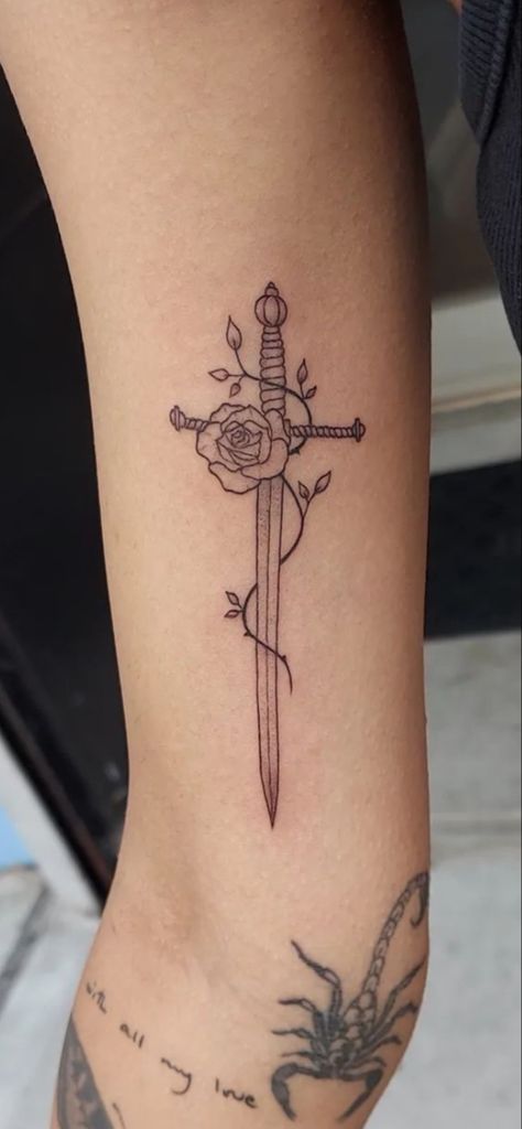 Rose With Swords Tattoo, Spine Dagger Tattoo, Girly Dagger Tattoo, Dagger Sternum Tattoo Women, Irish Rose Tattoo, Dagger Thigh Tattoo, Dagger And Flower Tattoo, Thigh Dagger Tattoo, Tiny Dagger Tattoo