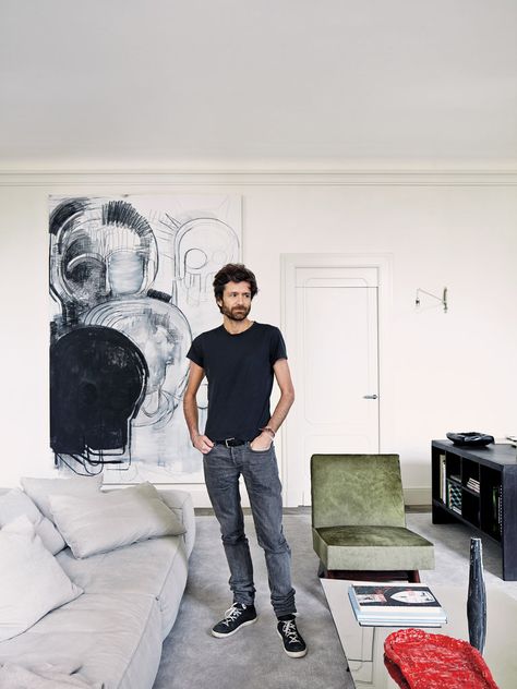 Dirand beside a Living Divani modular sofa: “It’s the first time I buy something as comfortable as that!” he says. The charcoal drawing is by Thomas Houseago. Paris Apartment Living Room, Joseph Dirand Interiors, Minimal Apartment, Joseph Dirand, Minimalist Apartment, Apartment Tour, Apartment In Paris, Pierre Jeanneret, Parisian Apartment