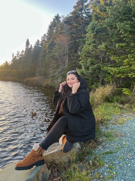 Plus size girl wearing black winter jacket from PENN., black leggings from Lulu Lemon, and suede winter boots from Cougar Shoes. Sitting on rocks next to pond with ducks swimming in winter. Black Outfit Winter, Newfoundland Canada, Outfit Winter, Casual Black, Newfoundland, Winter Style, Black Outfit, Suede Boots, Plus Size Fashion