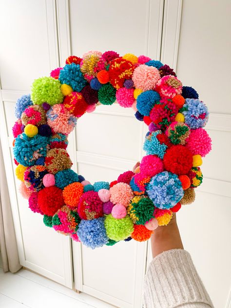 How To Make A Pompom Christmas Wreath Diy Christmas Pom Pom Garland, Yarn Holiday Decor, Pom Pom Christmas Tree Decorations, Pompon Christmas Decoration, Pompom Wreath Tutorial, Pompom Wreath Christmas Diy, Pompon Wreath Christmas, Wreaths Using Yarn, Diy Christmas Decorations Colorful