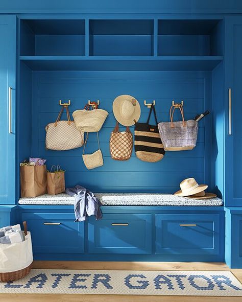 A bright blue-painted mudroom with built-in cabinets, bench and drawers, hanging straw bags and hats, and playful blue and white rug. Painted Mudroom, Bright Blue Paint, Color Inspiration Boards, Painting Shiplap, Mudroom Cabinets, Installing Shiplap, Blue And White Rug, Board Batten, Accent Wall Colors