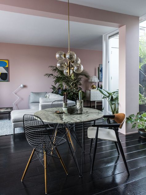 The house of Julien Rademaker & Maaike Chanowski. Image by Dim Balsem for Volkskrant Magazine, september 2015. Interior design & styling: Julien Rademaker & Maaike Chanowski. Pink wall, midcentury, vintage design, eames wire chair, marble table, plants, patio, black wooden floor, jordy van den nieuwendijk, interior design, interior styling Black Wooden Floor, Black Flooring, Dusty Pink Bedroom, Pink Bedroom Walls, Pink Bedrooms, Black Floor, Wooden Floor, Pink Wall, Dining Room Inspiration