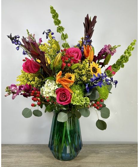 Floral Arrangements On Stands, Bright Summer Flower Arrangements, Vibrant Floral Centerpieces, Multicolor Floral Arrangement, Blue Orange Yellow Floral Arrangement, Bright Floral Arrangements, Summer Floral Arrangements, Small Floral Arrangements, Tabletop Floral Arrangements