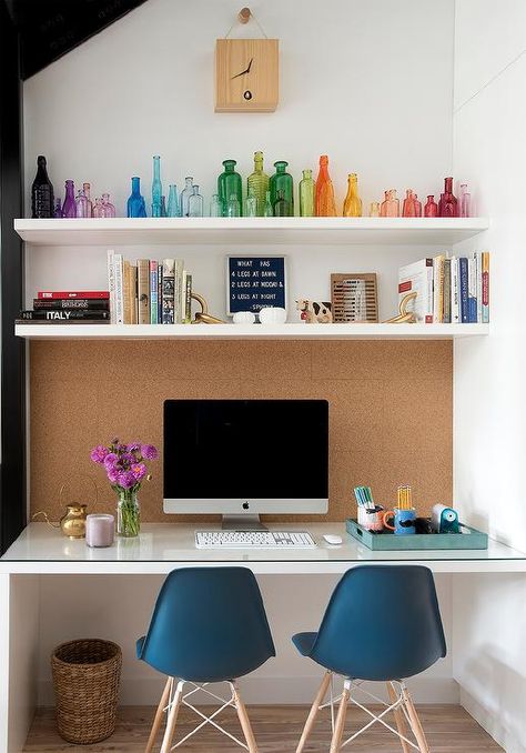 Pinboard over a kid's desk designed with two blue modern chairs and floating shelves styled with colorful accents. Big Desk In Bedroom, Over Desk Shelves, Desk With Shelves Above, Shelves Above Desk, White Floating Desk, Pinboard Ideas, Desk Nook, Glass Top Desk, Kids' Desk