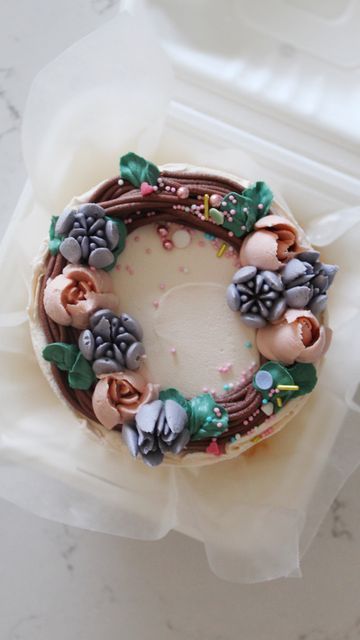 Jessica Harris on Instagram: "Floral Wreath Bento Cake It’s my flattop floral wreath cupcakes, but a bit bigger! Still obsessed with these #lunchboxcakes and they are the perfect little gift for Mother’s Day! This one is banana cake with peanut butter filling and Nutella buttercream. A new fav flavor combo of mine! This Wilton piping tip is perfect for wreaths or little nests, I’ll be doing another one this week using the new mini Russian piping tips I got in from @sugarandcrumbs2022 @colo Wilton Piping Tips, Wreath Cupcakes, Nutella Buttercream, Russian Piping Tips, Piping Tip, Bento Cakes, Bento Cake, Peanut Butter Filling, Cake Decorating Designs