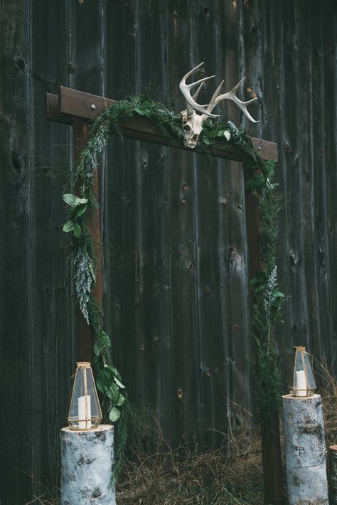 a moody Nordic wedding arch of dark stained wood, herbs and greenery, a skull with antlers and candle lanterns on each side Gothic Wedding Arch, Dark Fantasy Wedding, Bog Witch, Wiccan Wedding, Witch Wedding, Nordic Wedding, Pagan Wedding, Viking Wedding, Goth Wedding