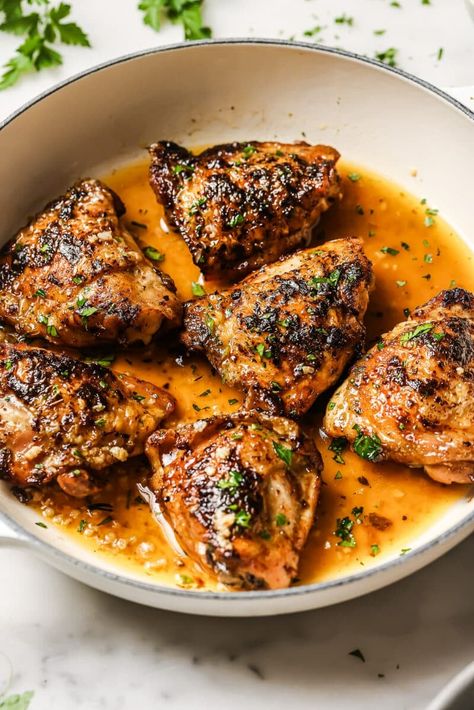 Pan seared chicken thighs in a skillet.