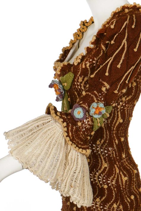 A good and rare Vivienne Westwood lace-knit wool dress, 'On Liberty' collection, Autumn-Winter 1994-95 gold label and size L, with integral corset, knitted and crochet flowers, 18th-century style engageant ruffle cuffs, bust approx 92cm, 36in This dress was designed to be worn with a bum-roll. Vivienne Westwood once stated that it was her 'favourite dress of all time'. Vivienne Westwood Crochet, Vivienne Westwood Knit, Knitted Corset, Vivienne Westwood Punk, Wool Knitted Dress, Party World, Pretty Stuff, Gold Labels, Black Lace Dress