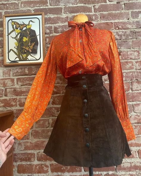 Look on Instagram: “Skirt is *Sold* 70s poet sleeve paisley tangerine blouse paired with a delicious 70s dark chocolate suede snap button skirt. Yum. Link in…” 70s Shirt Outfit, 70s Two Piece Outfit, Orange 70s Outfit, 70s Denim Skirt, Dark 70s Outfits, 70s Skirt Outfit, Black 70s Fashion, Skirt And Blouse Outfit, 70s Skirts