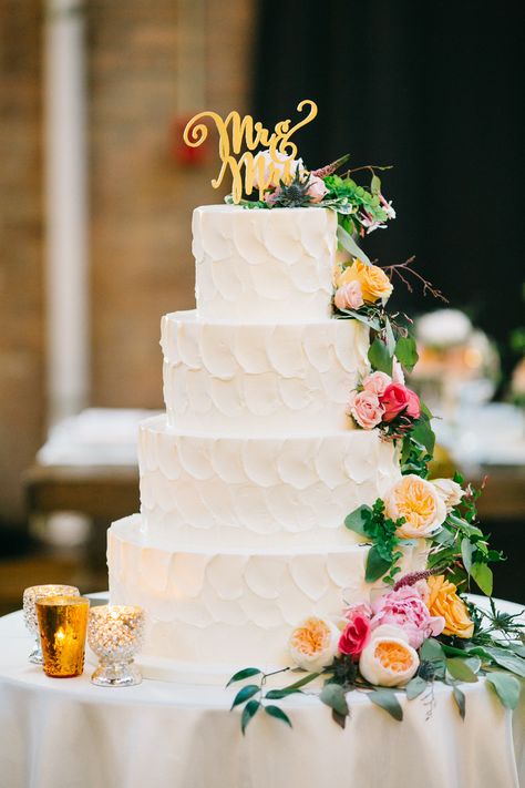 Marissa and Jeff's wedding cake was anything but expected. While the four-tier buttercream confection looked classic on the outside with scalloped white frosting, colorful cascading blooms and a whimsical "Mr. & Mrs." cake topper, the inside was one of a kind. “Each slice was made up of both coconut and banana cake, with layers of salted caramel, raspberry fudge, and cinnamon cream cheese fillings in between.  It sounds weird, but I swear it was magical,” Marissa says. “I'm secretly excited ... 3 Tier Wedding Cake, Orange Buttercream, Wedding Cake Fresh Flowers, Decor Cake, Buttercream Wedding Cake, Gorgeous Wedding Cake, Cake Wedding, Elegant Wedding Cakes, Wedding Cake Designs