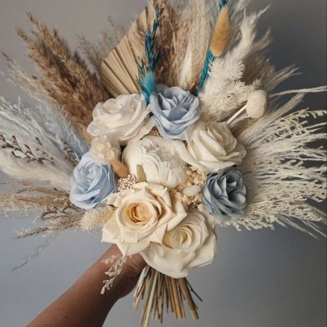 This stunning dried flower bouquet features a harmonious blend of soft blue and cream tones, accented with pampas grass and natural elements. Ideal for weddings or as a chic home decor piece, this bouquet combines elegance and boho charm. The delicate mix of preserved florals and textured grasses creates a unique and timeless arrangement, perfect for adding a touch of natural beauty to any setting. Bridal: height aprrox. 17 inch (40 cm) x width 16 inch (37cm) Bridesmaids: height 13 inch (32cm) x Blue Western Wedding, Pampas Grass Wedding Bouquet, Western Style Wedding, Pampas Grass Bouquet, Blue Bride, Grass Wedding, Rustic Bridal, Theme Color, Dried Flower Bouquet