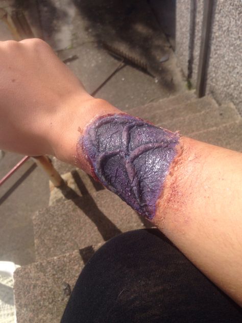 Dragon/ mermaid scales under skin. Done by me Ellie Sinclair. Really easy to do at home. • liuquid latex • cotton pads • purple, blue and red face paint. • glitter eye shadows (black for shading) • nose and scar wax for ripped skin. • fake blood for under ripped skin. Pad With Blood, Shading Nose, Face Paint Glitter, Red Face Paint, Dragon Mermaid, Scar Wax, Red Face, Glitter Eye, Eye Shadows