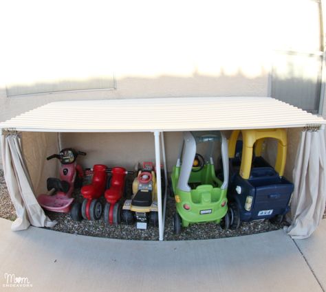 DIY:  How to Make a Covered Outdoor Storage Space - using PVC pipe, a drop cloth, corrugated roof panels and a few misc. supplies,  you can build a space to protect toys, garden supplies, etc. from the weather. If you don’t have a garage, and building a shed is not an option, this could be an affordable solution - via Mom Endeavors Kids Car Garage, Backyard Diy Projects, Backyard Projects, Backyard Fun, Toy Organization, Outdoor Toys, Diy Backyard, Outdoor Kids, Outdoor Play