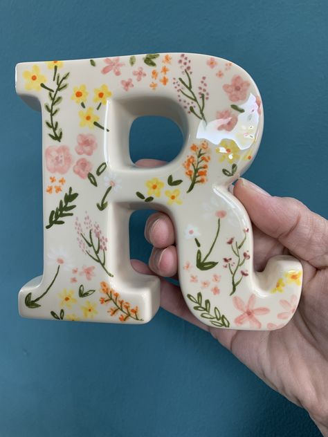 Beautifully delicate flowers painted at our pottery studio on a ceramic letter R Lettering On Pottery, Preppy Ceramics, Clay Crafts To Make For Your Boyfriend, Ceramic Letters Ideas, Preppy Pottery Painting, Paint Your Own Pottery Ideas Easy, Letter R Craft, Initial Letter Decor, Clay Letters