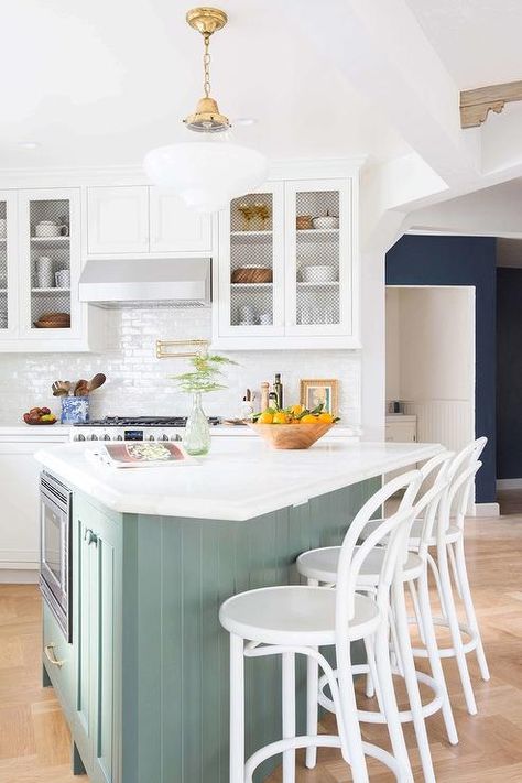 A vintage glass and brass light pendant illuminates a green beadboard triangular shaped kitchen island fitted with a microwave topped with honed white marble lined with white Bentwood Barstools. Cottage Tudor, Modern English Country, Kitchen Triangle, Organic Kitchen, Kitchen Transformation, Modern Organic, Kitchen Island Design, Island Design, Farmhouse Style Kitchen