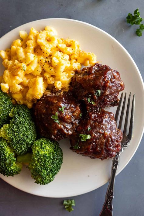 Close up of BBQ meatballs on a cream plate with mac and cheese and steamed broccoli. Easy Barbecue Meatballs, Bbq Meatballs And Mashed Potatoes, Mac And Cheese And Meatballs, Bbq Meatball Meals, Meat With Mac And Cheese, Bbq Beef Meatballs, Meal Ideas With Meatballs, Meatball Mac And Cheese, Bbq Meatball Dinner Ideas