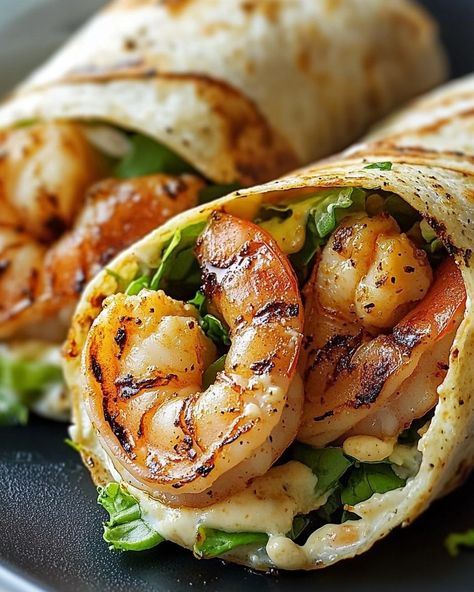 🦐🥬 𝑮𝑹𝑰𝑳𝑳𝑬𝑫 𝑺𝑯𝑹𝑰𝑴𝑷 𝑪𝑨𝑬𝑺𝑨𝑹 𝑾𝑹𝑨𝑷𝑺 🌯🦐 "A light, refreshing meal that brings family and friends together with a healthy, flavorful twist on the classic Caesar salad." 🍤 Ingredients 🍤 - 1 lb large shrimp, peeled and deveined - 1 tbsp olive oil - 2 cloves garlic, minced - 1 tsp smoked paprika - 1/2 tsp black pepper - Salt to taste - 1 tbsp lemon juice - 1 head romaine lettuce, chopped - 1/2 cup Caesar dressing - 1/4 cup Parmesan cheese, grated or shaved - 1/4 cup croutons (optional) - 4 large flour... Dinner Shrimp Ideas, Prawn Meals, Ceasar Salad Wrap Recipe, Shrimp Wraps Recipes, Shrimp Ceasar Salad Recipes, Grilled Shrimp Ceasar Wrap, Gourmet Meals, Shrimp Ceasar Salad, Grilled Shrimp Caesar Salad