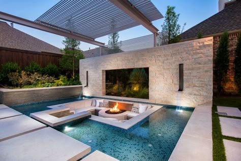 This modern and luxurious swimming pool has a spa with a fireplace, a sunken lounge with a firepit, a cantilevered deck, and floating stepper pads. #SwimmingPool #PoolDesign #LandscapingIdeas #PoolIdeas Sunken Fire Pit, Patio Seating Arrangement, Sunken Patio, Sunken Fire Pits, Terrasse Design, Luxury Pools, Modern Pools, Pool Lounge, Dream Pools