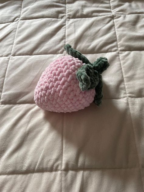 A crocheted strawberry plushie handmade with soft pink or red yarn. Strawberry Plushie Crochet, Pink Crochet Pattern, Pink Yarn Crochet Ideas, Crochet Strawberry Pillow, Red Crochet Ideas, Cute Pink Crochet, Strawberry Crochet Pattern, Strawberry Plushie, Crocheted Strawberry