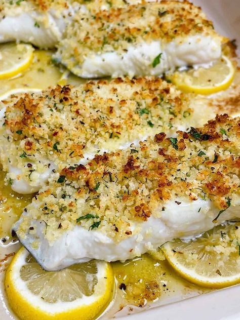 easy lemon garlic baked halibut recipe hero image close up cooked with crispy topping on a bed of lemon Lemon Caper Halibut, Ina Garden Fish Recipes, Spicy Halibut Recipes, Crusted Halibut Recipes Baked, Petrale Sole Recipes Baked, Baked Halibut Recipes Parmesan Crusted, Best Halibut Recipes Baked, Lemon Halibut Recipes, Oven Baked Halibut