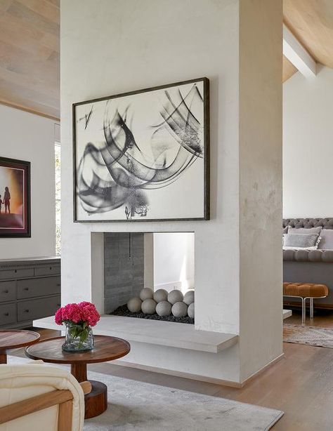 Master bedroom designed with a concrete double sided fireplace accented with a stunning black and white abstract wall art. Coats Homes, Sleek Fireplace, Fireplace Facing, White Mantel, Two Sided Fireplace, Fireplace Frame, Double Sided Fireplace, Contemporary Patio, Concrete Fireplace