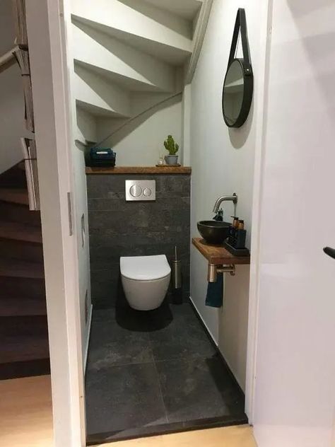 A modern powder room under the stairs clad with grey tile, a wall mounted toilet, a black bowl sink and a mirror Toilet Onder Trap, Bath Under Stairs, Small Wc Ideas, Under Stair Bathroom, Green Wc, Inspiration Wc, Wc Room, Small Wc, Understairs Toilet