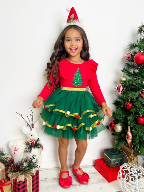 For the jolliest look, our Christmas tree tutu dress is just perfect! With ruffle details, a layered gold-lined tulle skirt, and a festive print, this magical number will have your little girl twinkling and twirling in delight. Finished with pom pom details for extra charm. Available in sizes 2T-10Y.