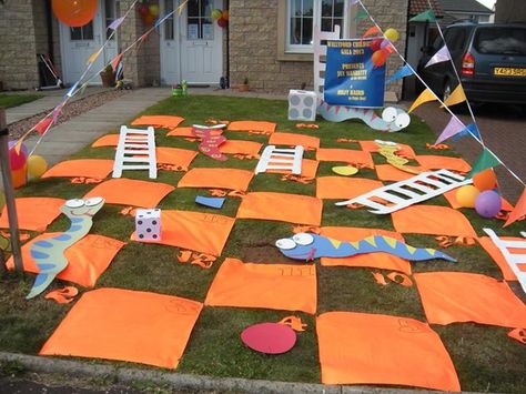 Borders Scrapstore posted this fabulous giant Snakes 'n' Ladders game made from scrapstore materials. Gloucestershire Resource Centre http://www.grcltd.org/scrapstore/ Giant Snakes And Ladders, Shoots And Ladders Game Diy, Chutes And Ladders Decorations, Active Games For Kids, Snake Games, Giant Outdoor Games, Giant Yard Games, Board Game Themes, Library Games