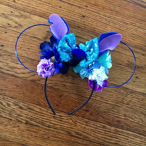 These Stitch inspired ears feature a blue bow with his ears and nose accent, matching florals and blue wire ears. DETAILS: ❀ Each headband is made to order so arrangement and florals will vary ❀ These are handcrafted and delicate, we recommend being careful with them ❀ Our satin Stitch Items, Ear Ideas, Stitch Ears, Diy Disney Ears, Disneyland Ears, Diy Mickey Ears, Disney Mouse Ears, Disney Themed Outfits, Disney Headbands