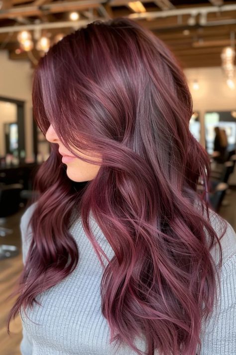 Woman with long, wavy dark burgundy hair inside a salon. Maroon Hair Burgundy Wine, Cherry Wine Hair, Cherry Balayage, Dark Maroon Hair, Mahogany Highlights, Maroon Highlights, Cherry Brown Hair, Cherry Cola Hair Color, Cherry Cola Hair