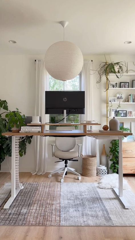 A minimalist home office space adorned with large indoor plants and natural light, showing a woman casually sitting in a modern chair while using her smartphone. The setup includes a clean wooden desk, ergonomic seating, and a calming atmosphere that encourages both work and relaxation. Home Office Workout Room Combo, Office And Workout Room Combo, Office With Couch And Desk, Women Home Office Ideas, Workspace Home Office, Office Work Desk, Cozy Office Space, Workspace Home, Interior Design Layout