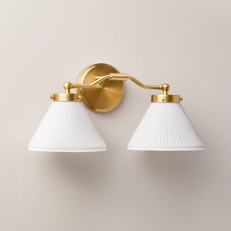 Illuminate your bedroom, living room or hallway in luxurious style with this Reeded Milk Glass 2-Bulb Vanity Wall Sconce from Hearth & Hand™ with Magnolia. Designed with two white reeded milk glass cone shades and a gold-tone metal fixture, this vanity wall sconce requires two E26 bulbs and features a one-way light setting. The sconce has no switch and requires hardwired installation (tools not provided), and it comes with the required mounting hardware to save you a bit of time. Hearth & Hand™ French Vanity Light, Over Mirror Lighting Bathroom, Lighting Over Bathroom Mirror, Two Light Vanity Fixture, Powder Bath Lighting, Powder Room Lighting Above Mirror, Bathroom Vanity Lighting Black, Wall Sconces Hallway, Gold Bathroom Light Fixtures