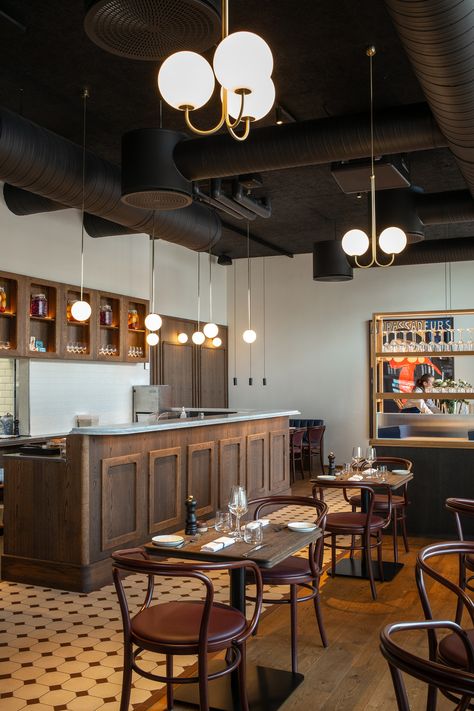 Bistro Le Bleu in Aarhus, Denmark has an airy and light interior design with large windows and a high ceiling. To ensure the bistro’s good acoustic qualities, black Troldtekt acoustic panels were chosen for the entire ceiling to camouflage the black-painted ventilation pipes and similar installations. #goodacoustics #holzwolleplatten #träullsplattor #woodwoolpanels #troldtekt | Architects: SLETH Modern French Bistro, Cafe Ceiling, Light Interior Design, Dark Wooden Furniture, Recess Lights, Acoustics Design, Bistro Interior, Bistro Decor, Resturant Design