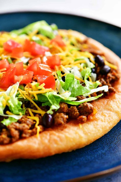 Indian Tacos, also know as Navajo tacos, are a Native American taco made on tender, crispy fry bread topped with taco meat, lettuce, cheese, and tomatoes. Native American Tacos, Indian Taco Recipes, Indian Taco, Navajo Tacos, Cheddar Cheese Curds, Indian Tacos, Easy Taco Recipes, Jamaican Jerk Chicken, Gunny Sack