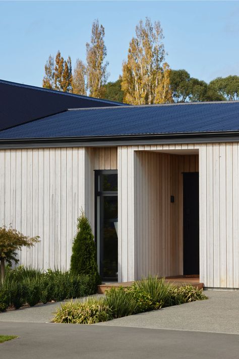 Modern farmhouse with a sleek black roof and vertical cladding. The clean lines and natural materials create a timeless aesthetic. #farmhousemodern #homeinspiration #architecture #interiordesign #modernhome #woodensiding #blackroof #modernfarmhouse #homeexterior #landscaping #exteriorhomedesign #house exterior #homefacade Modern Exterior Board And Batten, Millboard Cladding, Modern Farmhouse Entrance, Vertical Cladding, Farmhouse Entrance, Black Roof, House Design Ideas, Entrance Design, Timeless Aesthetic