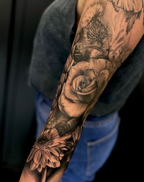 Realism tattoo of flowers on a woman's arm. Black and grey tattoos by Toni Moore Black And Grey Floral Tattoo Shoulder, Black And Grey Half Sleeve Tattoo, Black And Grey Floral Sleeve Tattoo, Realism Flower Tattoo Sleeve, Flower Realism Tattoo, Black And Grey Leg Sleeve, Realism Flower Tattoo, Black And Grey Flower Tattoo, Realism Tattoo Sleeve